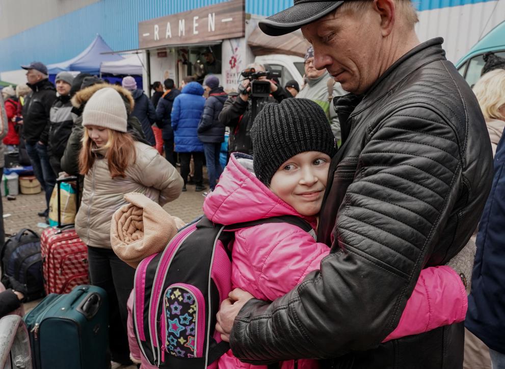girl hugging her father at the border in Ukraine
