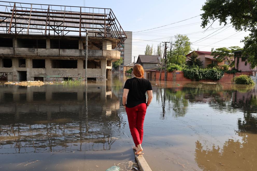 A woman looks at a flooded street in the town of Kherson, following flooding caused by damage sustained at the Kakhovka HPP dam